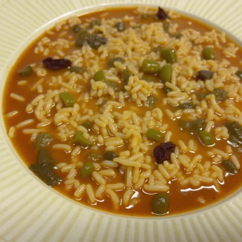 A cozy kitchen setting with a steaming bowl of Arroz de sopa de cebola francesa featuring caramelized onions, melted cheese, and fresh parsley, accompanied by toasted baguette slices.